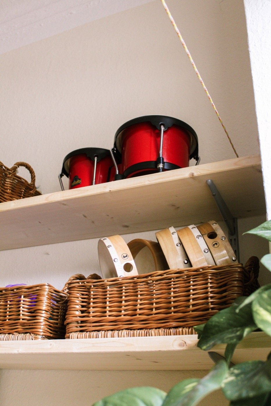 Trommeln und Körbe mit Instrumenten im Regal